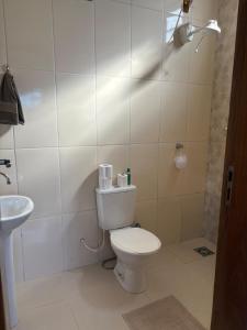 a bathroom with a toilet and a sink at Casa charmosa familiar in Chapada dos Guimarães +16 photos