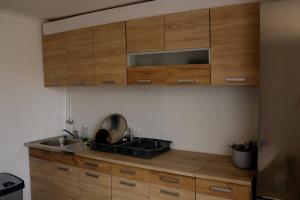 a kitchen with wooden cabinets and a sink at DrótSzarvas Üdülőház in Bogács +3 photos