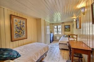 a bedroom with two beds and a desk and a table at Chalet Vallonette in Chateau-d'Oex