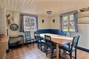 a dining room with a wooden table and chairs at Chalet Vallonette in Chateau-d'Oex