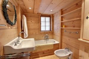 a bathroom with a sink and a toilet and a tub at Chalet Vallonette in Chateau-d'Oex