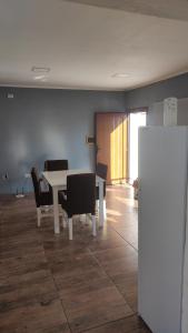 a dining room with a table and chairs and a refrigerator at rocky in Concordia