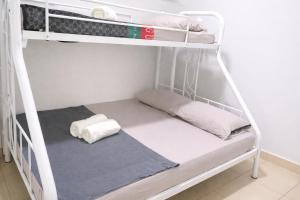 a bunk bed with two pillows and towels on it at JAA Homes 1-8 Pax Family Stay Jalan UMS KK in Kota Kinabalu