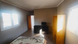 a bedroom with a bed and a desk and two windows at rocky in Concordia