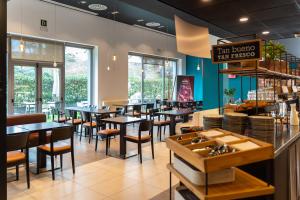 a dining room with tables and chairs in a restaurant at Ibis Barcelona Mollet in Mollet del Vallès