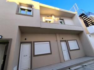 a house with three doors and a balcony at Anthouli Homes 2, steps from beach and centre in Kardamaina