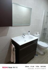 a bathroom with a sink and a toilet and a mirror at La ERA in Aldeadávila de la Ribera +4 photos
