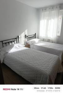 two beds in a bedroom with white walls at La ERA in Aldeadávila de la Ribera