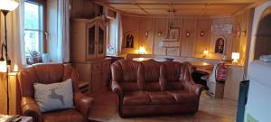 a living room with two chairs and a kitchen at Haus Ollie in Matrei in Osttirol