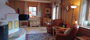 a living room with two chairs and a television at Haus Ollie in Matrei in Osttirol