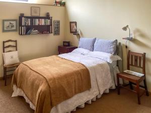 a bedroom with a bed and a book shelf at Stepping Gate Cottage in Scalby