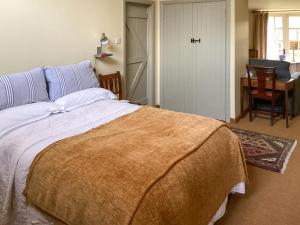 a bedroom with a large bed and a desk at Stepping Gate Cottage in Scalby