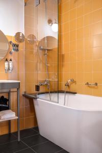 a bath tub in a bathroom with orange tiles at Rosário Suites Townhouse in Porto +67 photos