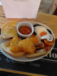 a plate of food with eggs sausage beans and toast at Fleur De Lis Hotel in Sandwich