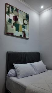 a bed in a room with a painting on the wall at azafa hotel in Lamobuang