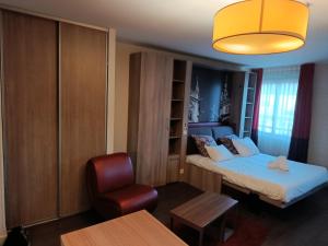 a small room with a bed and a chair at Studio au-dessus de l'Orne in Caen