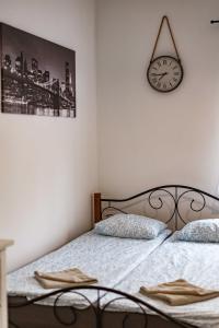 a bedroom with a bed and a clock on the wall at LénApartman - Holiday in Pécs