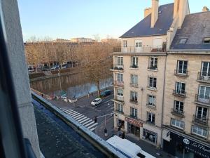 a view from a window of a street and buildings at Studio au-dessus de l'Orne in Caen