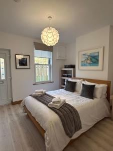 a bedroom with a large bed and a chandelier at Orebank Cottage in Millom