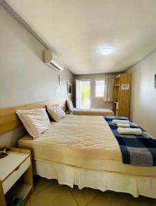 a bedroom with a large bed with a window at Pousada Pérola do Mar in Tamandaré +23 photos