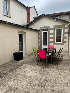 a patio with a table and chairs in front of a house at La Berge in La Flocellière