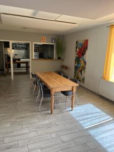 a dining room with a wooden table and chairs at La Berge in La Flocellière