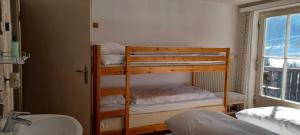 a bedroom with a bunk bed and a bathroom with a sink at Haus Ollie in Matrei in Osttirol
