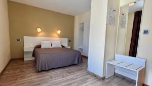 a small bedroom with a bed and a table at Hotel Celymar in Benidorm