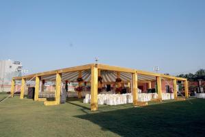 a large tent with tables and chairs in a field at Avsar Resort in Verāval