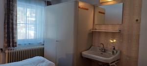 a bathroom with a sink and a mirror and a bed at Haus Ollie in Matrei in Osttirol +14 photos