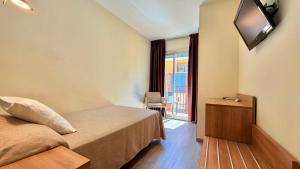 a hotel room with a bed and a flat screen tv at Hotel Celymar in Benidorm