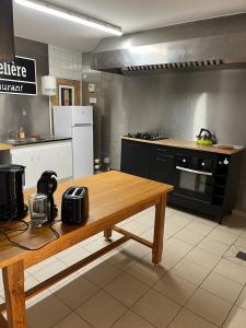 a kitchen with a wooden table and a counter top at La Berge in La Flocellière +6 photos