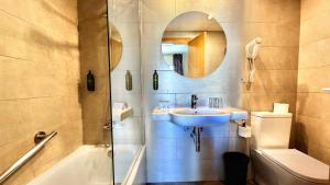 a bathroom with a sink and a toilet and a mirror at Hotel Celymar in Benidorm +16 photos