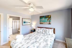 ein Schlafzimmer mit Bett und Deckenventilator in der Unterkunft Palms Delight in Kitty Hawk + 30 Fotos