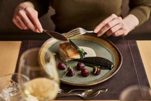 a person eating a plate of food on a table at Falkensteiner Hotel Schladming l 4 Star Superior in Schladming +38 photos