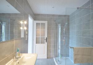 a bathroom with a sink and a shower with a glass door at Joli Canard in Badefols-dʼAns