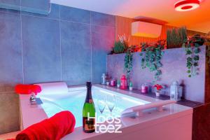 a bathroom with a tub with a bottle of champagne at Expérience des sens in Grézieu-la-Varenne