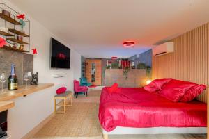a bedroom with a red bed in a room at Expérience des sens in Grézieu-la-Varenne +30 photos