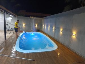 a man standing in a bath tub in a room at Área de Lazer BR 267 in Bataguaçu