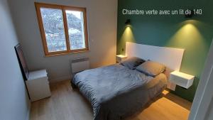 a bedroom with a bed and a window at Gite La Cueille in Saint-Claude