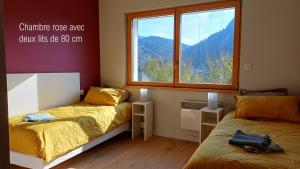 a bedroom with two beds and a window at Gite La Cueille in Saint-Claude +9 photos