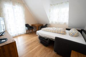 a small bedroom with a bed and two chairs at Ferienwohnung Elster in Stade