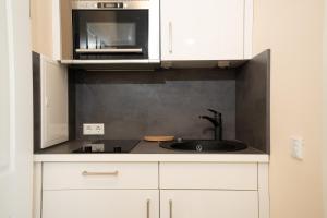 a kitchen with a sink and a microwave at Ferienwohnung Elster in Stade