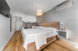 a bedroom with a large bed and a kitchen at Apartments Kartulina in Brela