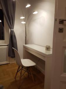 Cette chambre comprend un bureau, une chaise et une lampe. dans l'établissement Supreme City Center Apartment, à Budapest