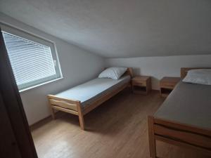 ein kleines Schlafzimmer mit einem Bett und einem Fenster in der Unterkunft Vila Arapović, Maloševići 56 in Buna