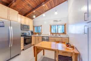 a kitchen with a wooden table and stainless steel appliances at Green Tree Cottage in Mendocino +2 photos