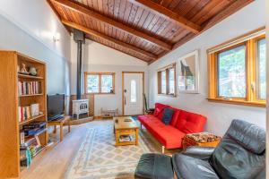 a living room with a red couch and a tv at Green Tree Cottage in Mendocino