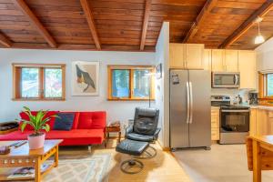 a living room with a red couch and a refrigerator at Green Tree Cottage in Mendocino