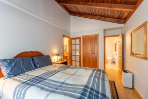 a bedroom with a bed with a blue and white comforter at Green Tree Cottage in Mendocino